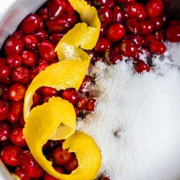 cranberries and lemon peel and white sugar in a pot