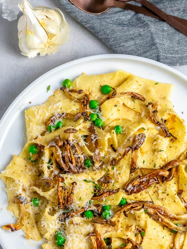 mushroom pappardelle pasta recipe on white plate and garlic