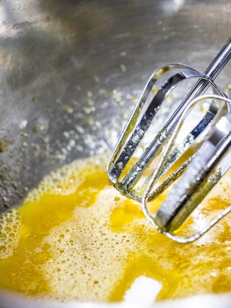 egg yolk with whisk in metal bowl