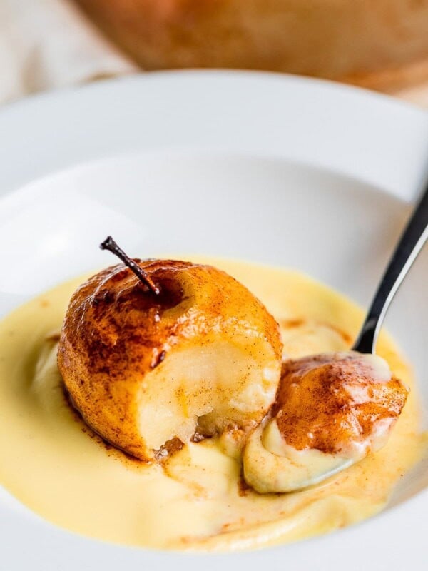 baked cinnamon apples with spoon in white bowl