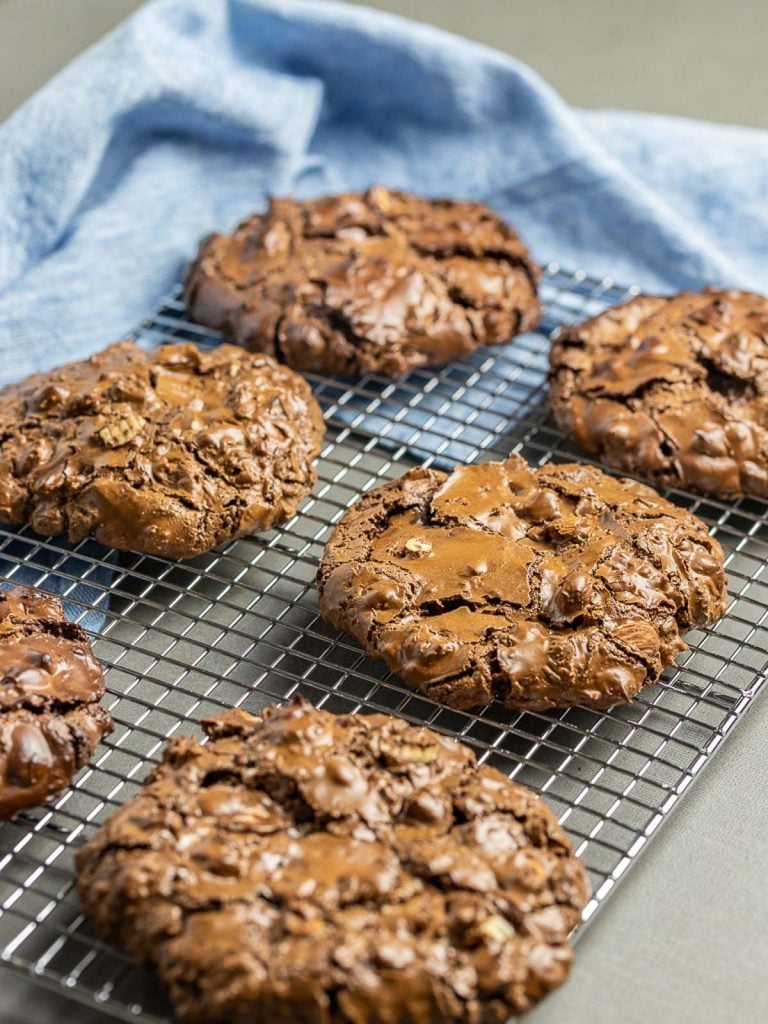 Six chocolate cookies on a baking pan with blue napkin