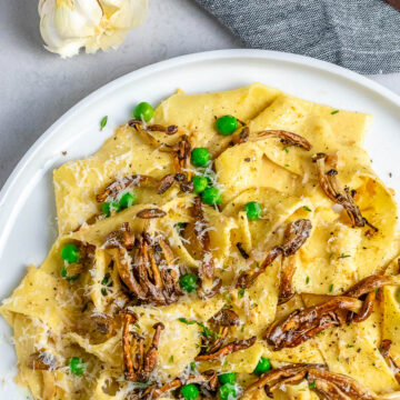 mushroom pappardelle pasta recipe on white plate and garlic