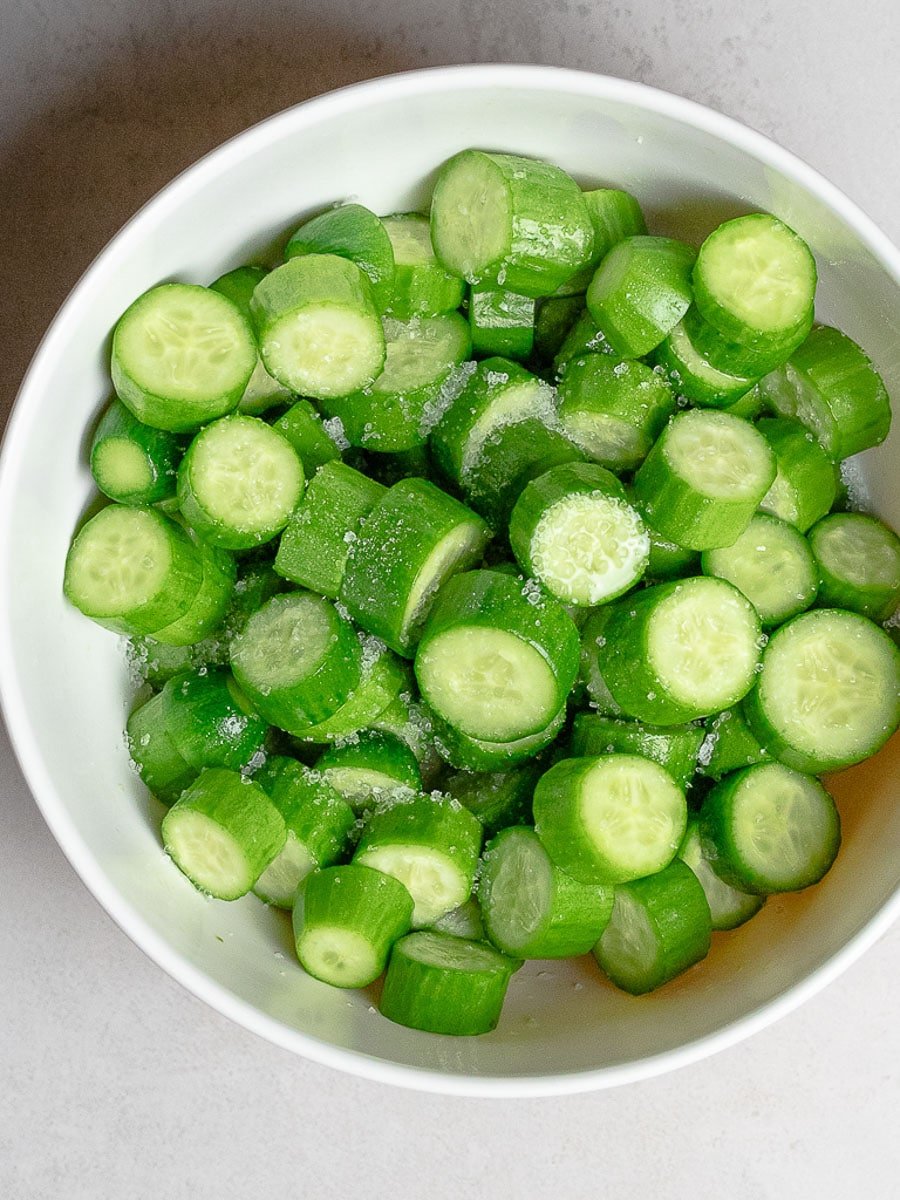 chopped persian cucumbers with salt in a bowl