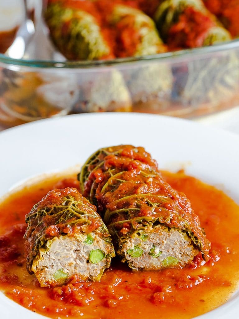 inside of easy stuffed cabbage rolls with meat filling on a white plate covered in a red tomato sauce