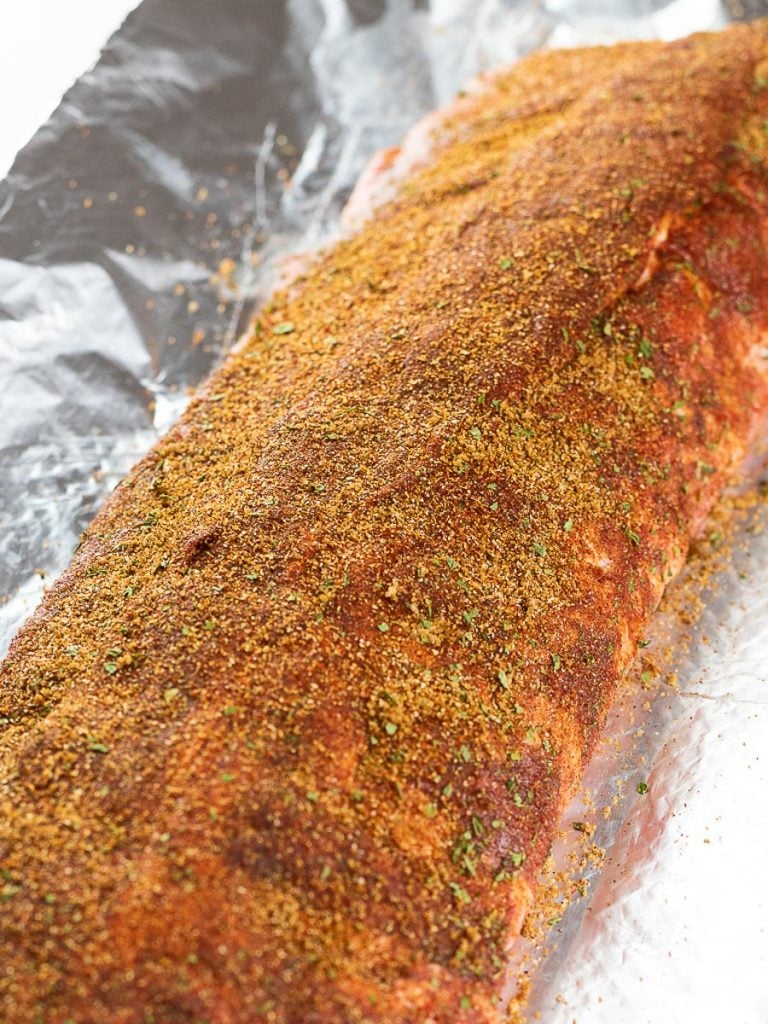 baby back ribs covered with dry rub on foil