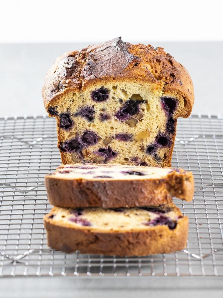 Lemon blueberry bread with a golden brown crunchy crust on a wire rack