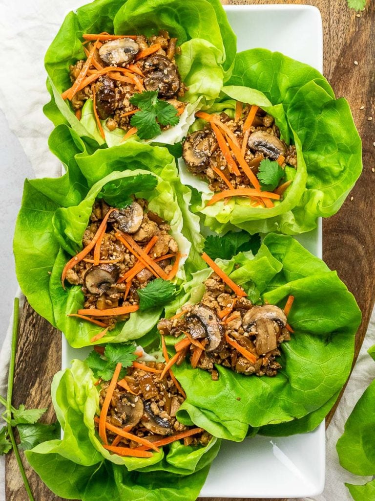 PF Chang's vegetarian lettuce wraps with tofu, mushrooms, carrots, and lettuce placed on a wooden board