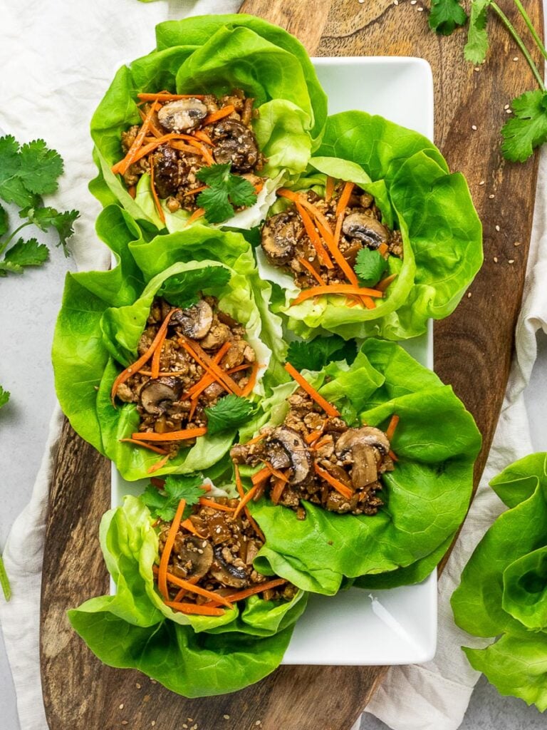  PF Chang 's vegetarian lettuce wraps with tofu, mushrooms, carrots, and lettuce on a wooden board