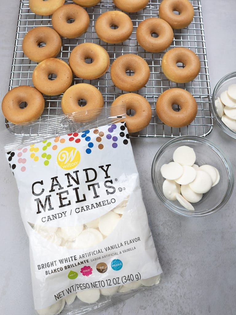 mini donuts on a rack with white candy melts