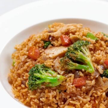 Thai red curry chicken fried rice with broccoli and chicken in a white bowl
