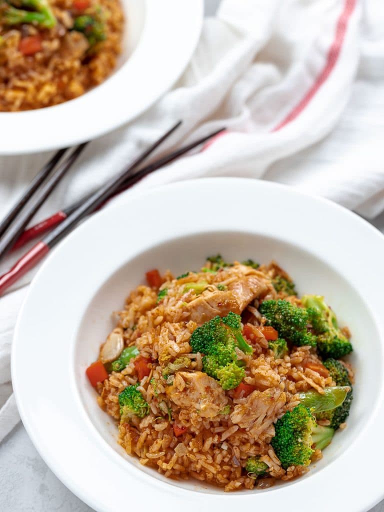 Thai red curry chicken fried rice with broccoli and chicken in a white bowl