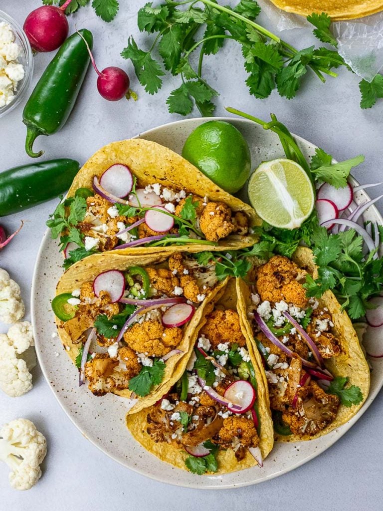 roasted chipotle cauliflower tacos with lime, radish, jalapenos in corn tortillas