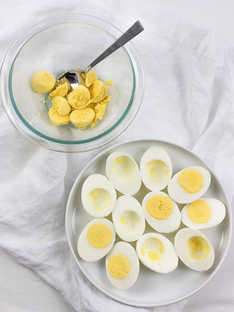 hard boiled eggs cut in half with yolks in a small glass bowl