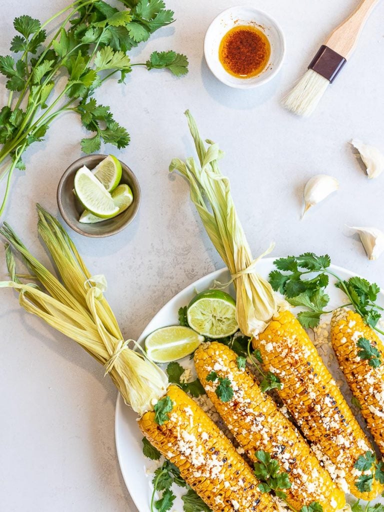 Healthy Grilled Mexican Street Corn on the cob (Elotes) with lime, cilantro, and garlic cloves
