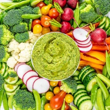 cilantro jalapeno hemp seed hummus surrounded by a vegetable platter