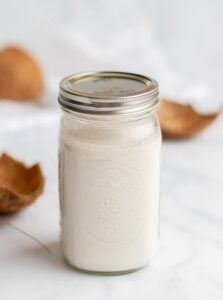homemade coconut milk in a mason jar with coconut shells