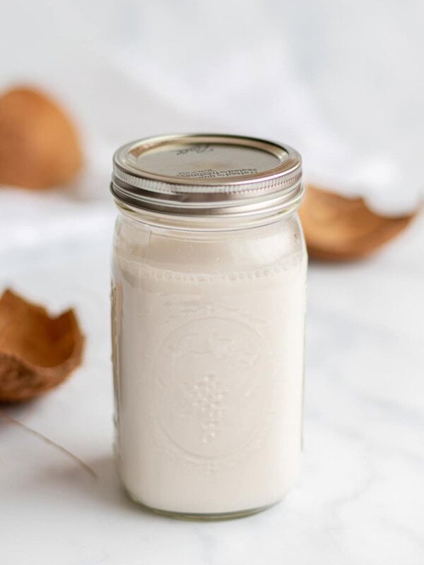 homemade coconut milk in a mason jar with coconut shells