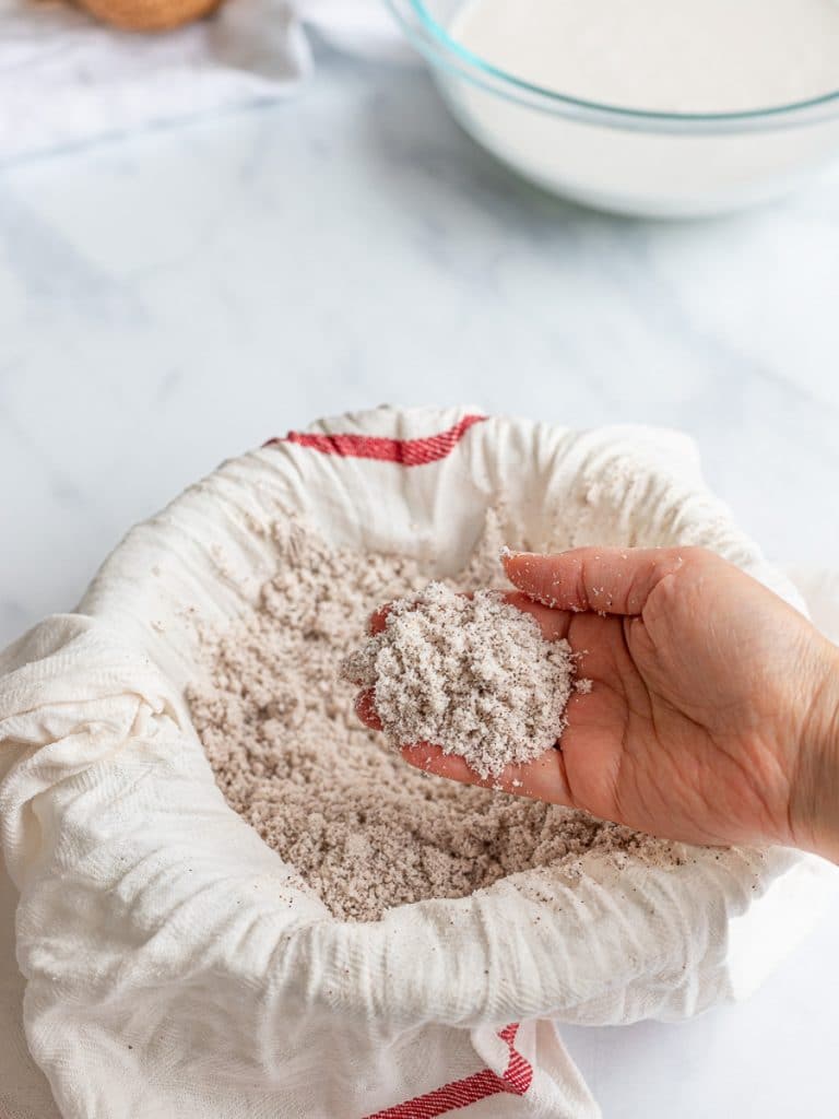 homemade coconut meal or coconut flour in a bowl with cheesecloth