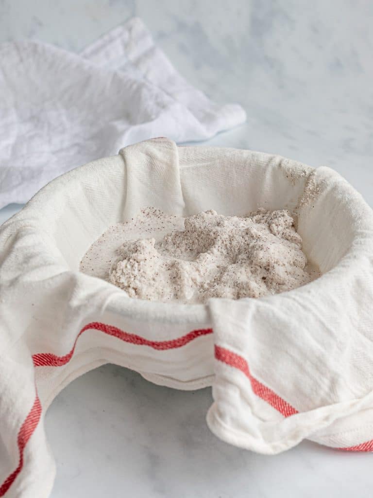 homemade coconut milk in a bowl with cheesecloth