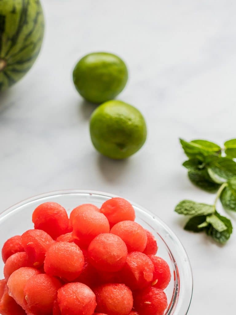 watermelon balls in a glass bowl with lime and mint
