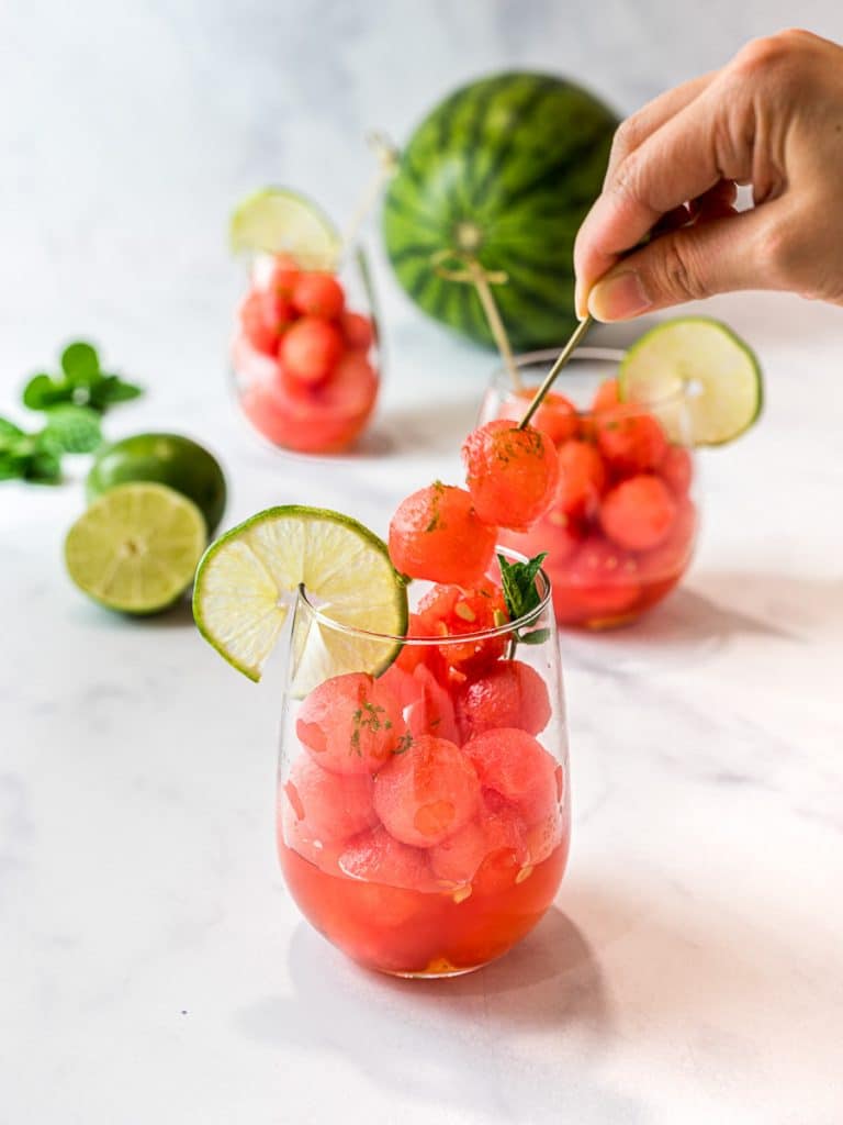 watermelon balls with lime and mint simple syrup in a clear glass cup