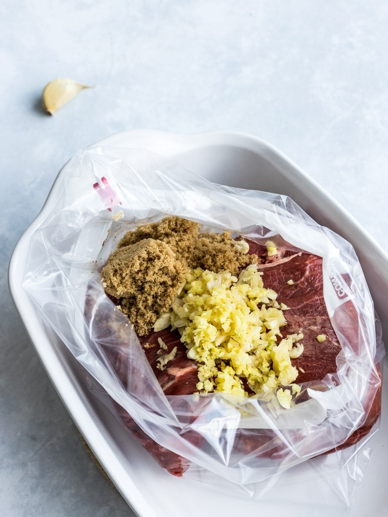 Flank steak marinated with brown sugar and garlic in a plastic ziplock bag
