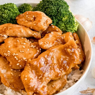 bowl of honey garlic chicken stir fry with steamed broccoli and steamed rice