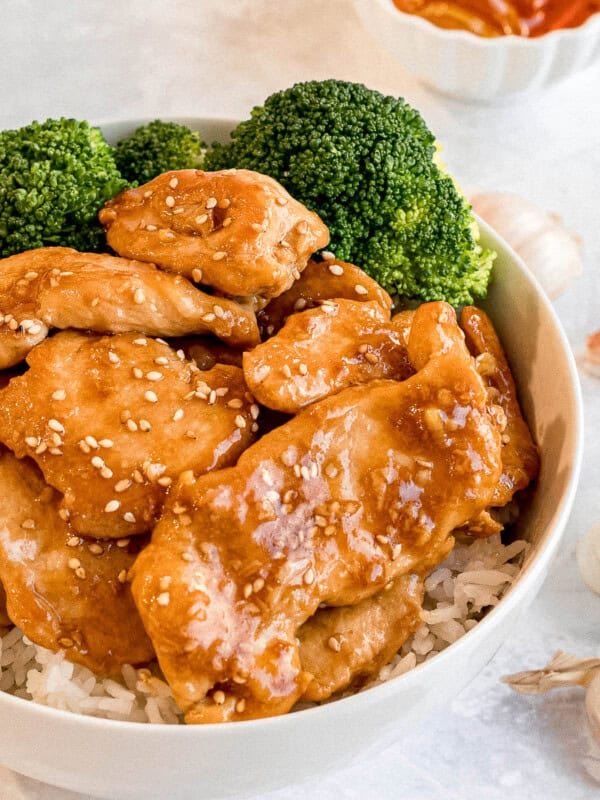 bowl of honey garlic chicken stir fry with steamed broccoli and steamed rice