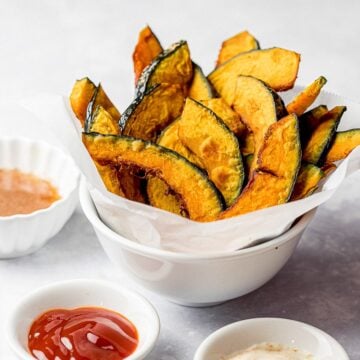 kabocha squash fries in a white bowl with ketchup and condiments