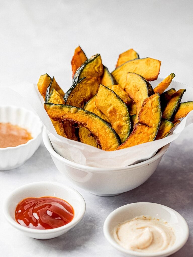 kabocha squash fries in a white bowl with ketchup and condiments