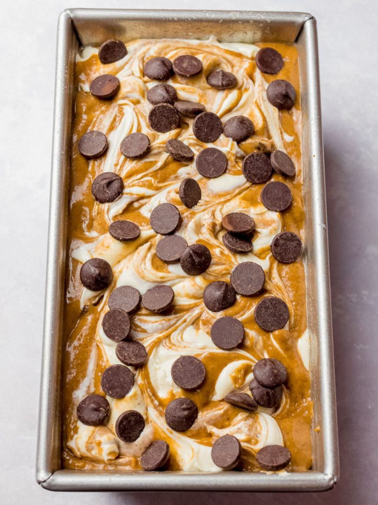 batter for pumpkin chocolate chip bread with cream cheese swirls in a loaf pan