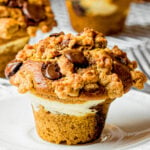 pumpkin chocolate chip muffins with cream cheese filling and streusel topping on a white plate