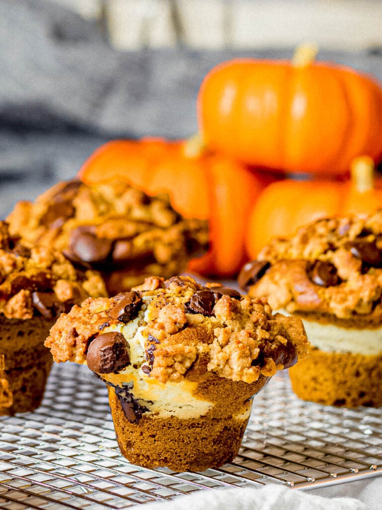 pumpkin chocolate chip muffins with cream cheese filling and streusel topping on a cooking rack