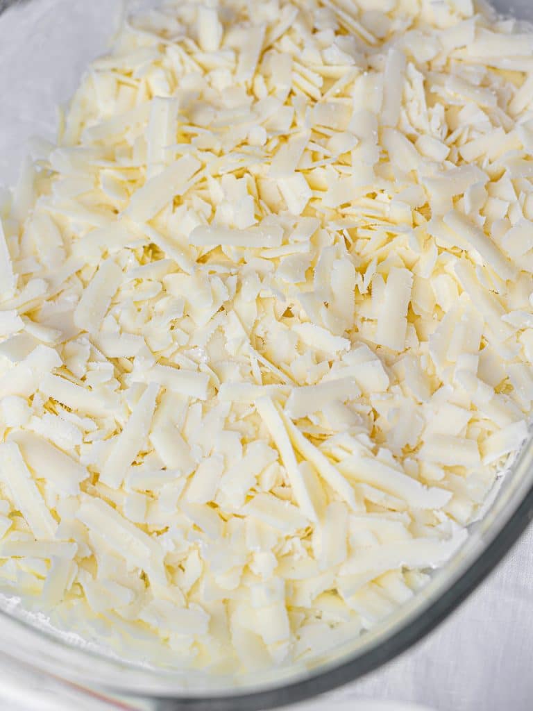 shredded white cheddar cheese in a dish