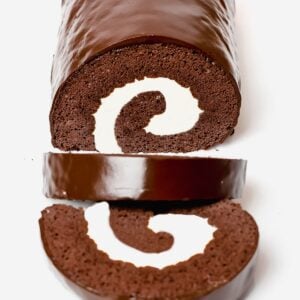 chocolate roll cake, swiss roll cake filled with cream and covered in a chocolate ganache glaze