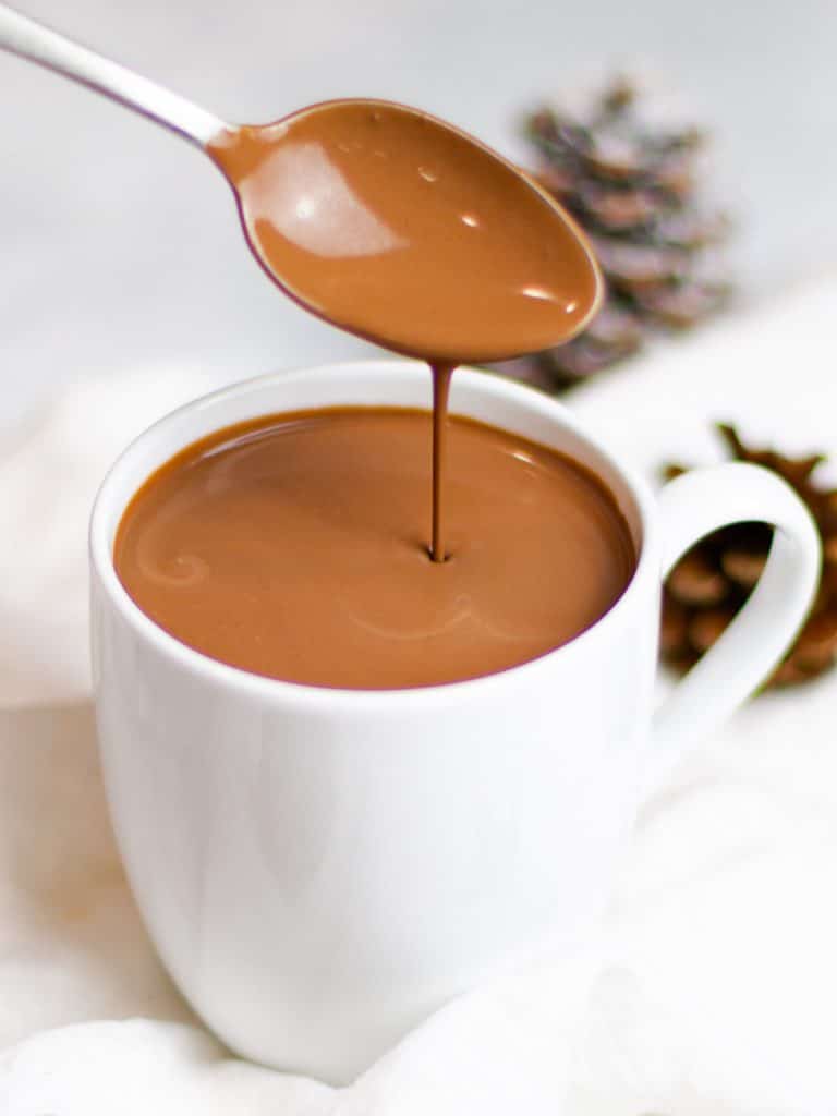 rich and creamy homemade hot chocolate dripping off a spoon