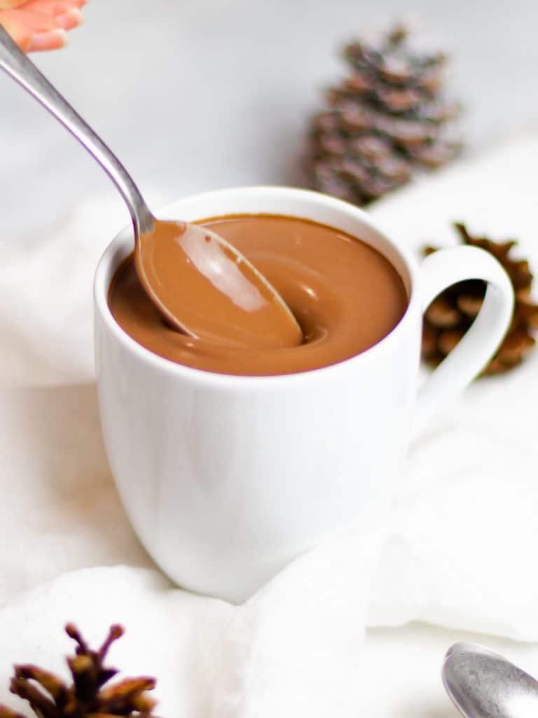 rich and creamy homemade hot chocolate in a white mug with a spoon