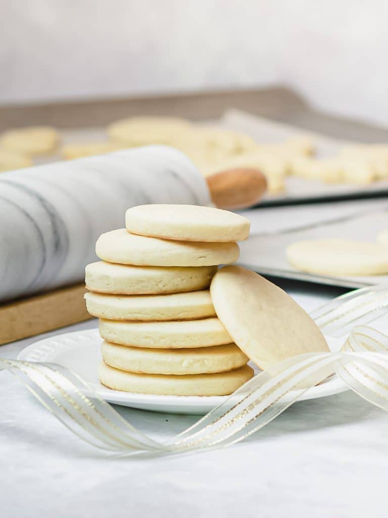 stack of soft cut out sugar cookies on a white plate