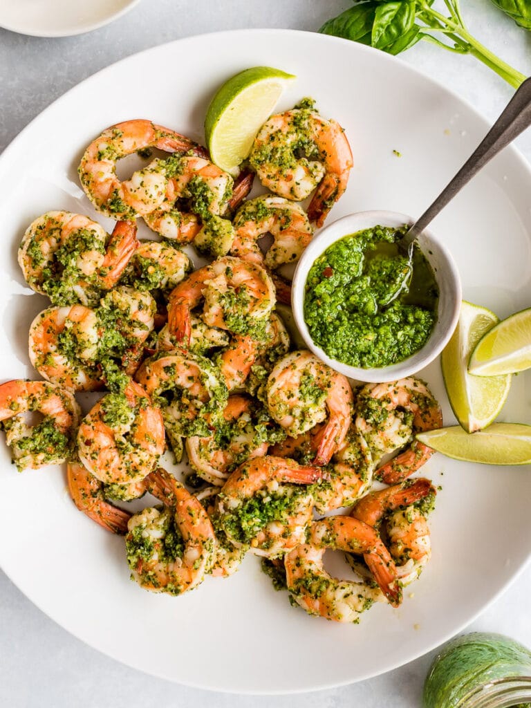 cilantro lime shrimp with a bowl of cilantro lime sauce on a white plate with lime wedges; low carb shrimp