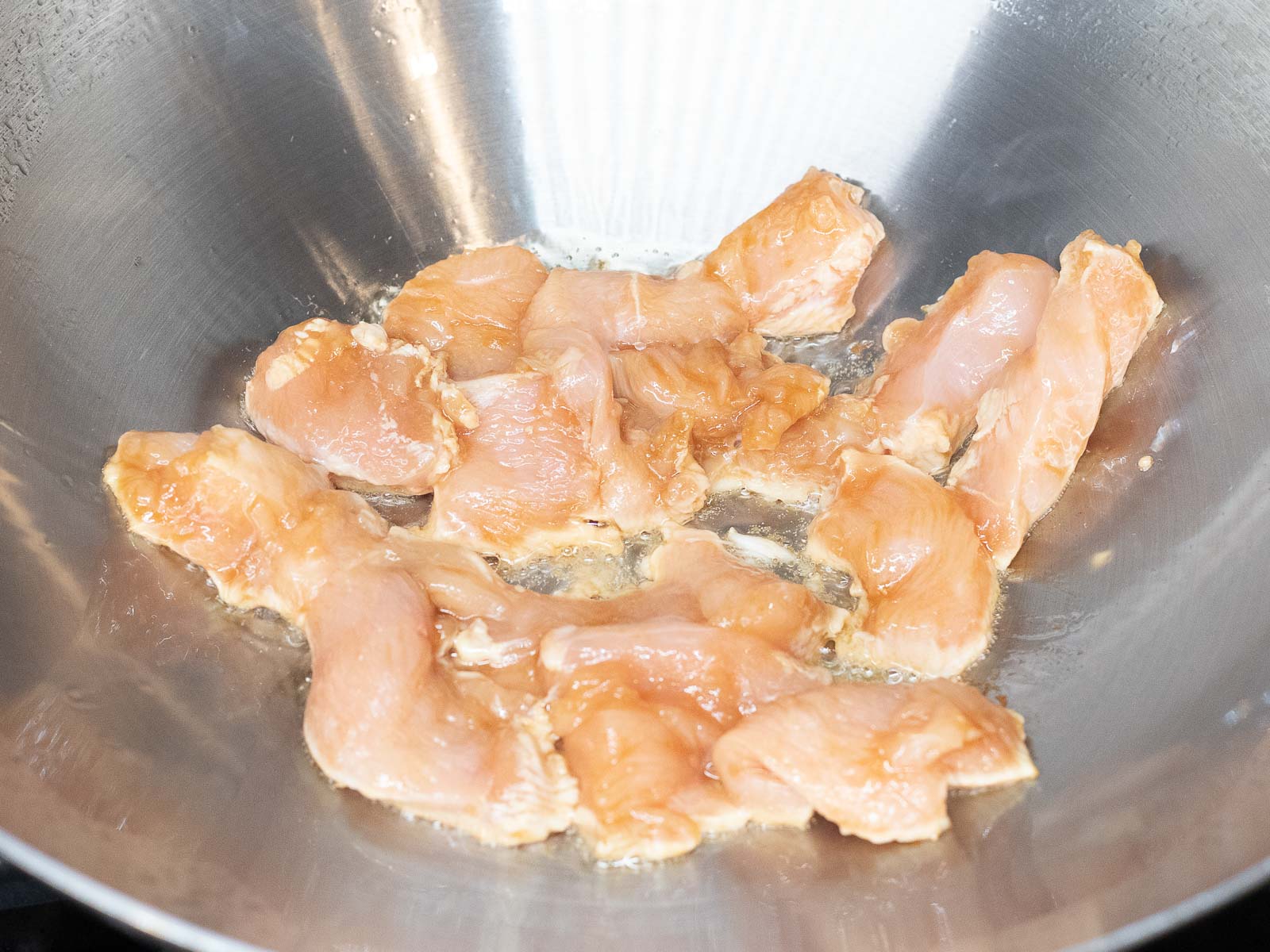 chicken breast cooking in a wok