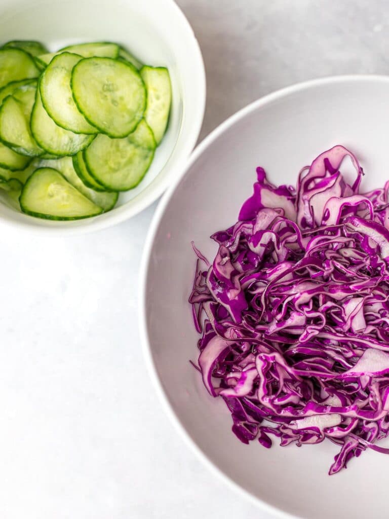 shredded red cabbage with cucumber slices in a bowl