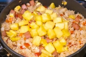 fried rice with spam and pineapple chunks in a pan