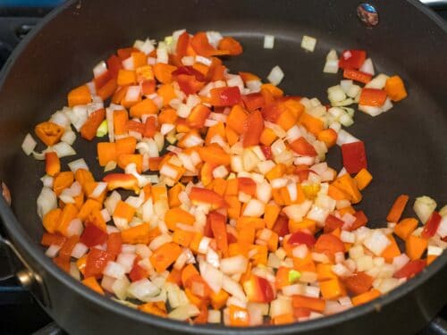 red bell peppers, carrots, and onions stir fried in a pan