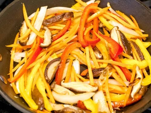 stir fried carrots, shiitake mushrooms, and bell peppers in a pan
