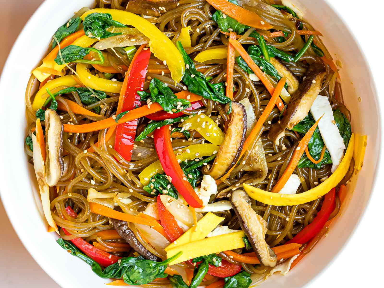 Korean japchae noodles with mushrooms, red peppers, carrots, and spinach