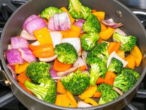 broccoli, peppers, and red onion stir fried in a pan