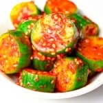 spicy Korean cucumber salad (Oi Muchim) with sesame seeds on a white plate
