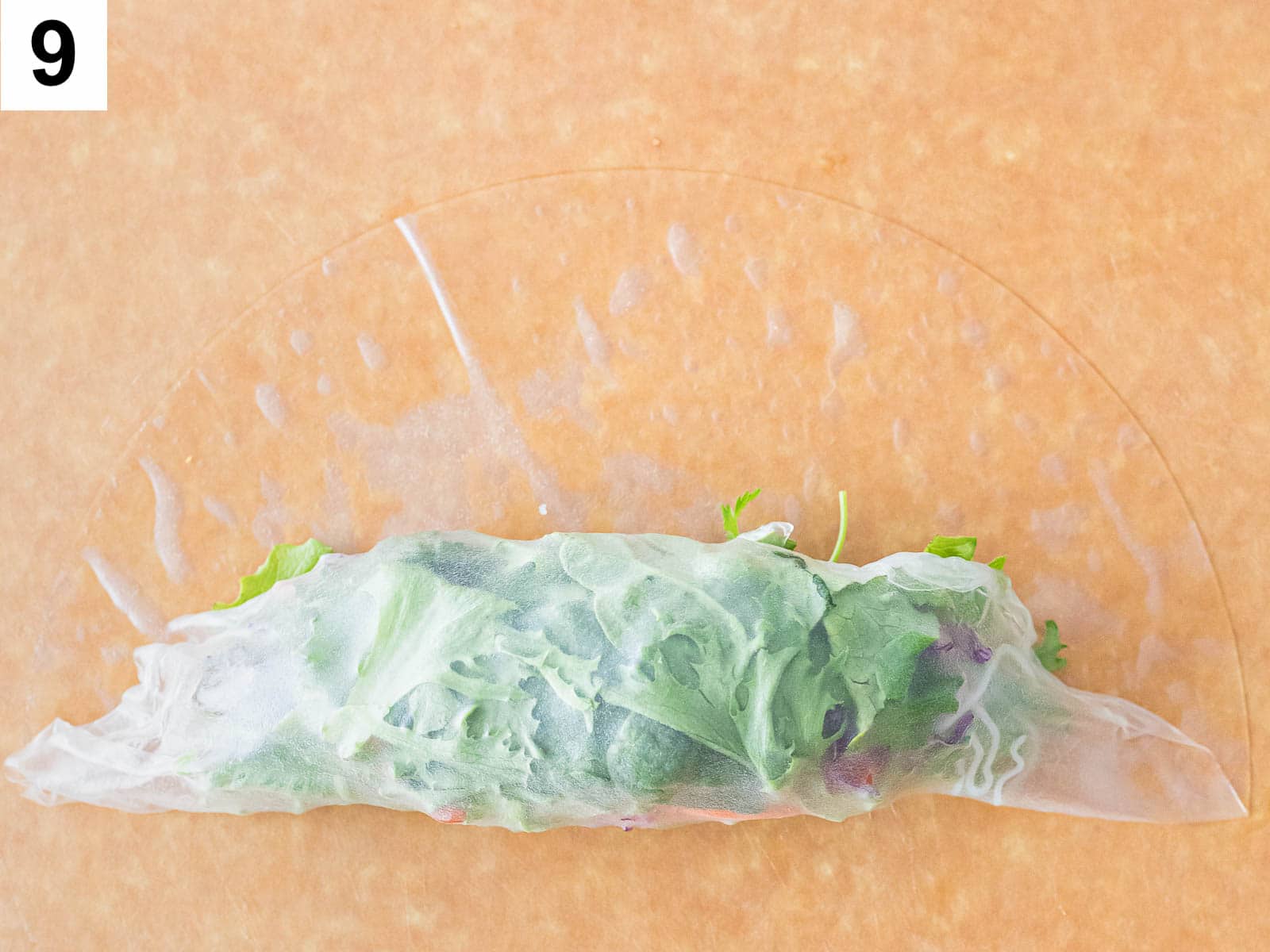 summer roll being rolled up with a rice paper wrapper
