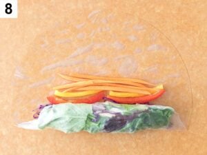 wrapping summer rolls with rice paper and carrots and pepper