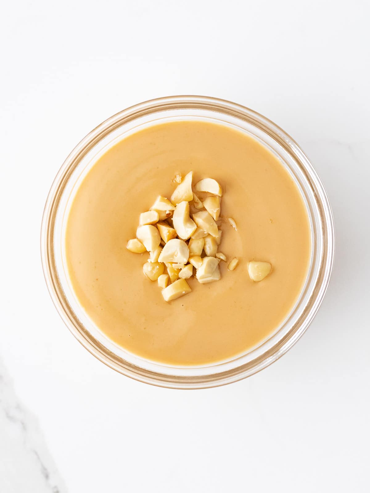 Vietnamese peanut sauce with crushed peanuts in a glass bowl